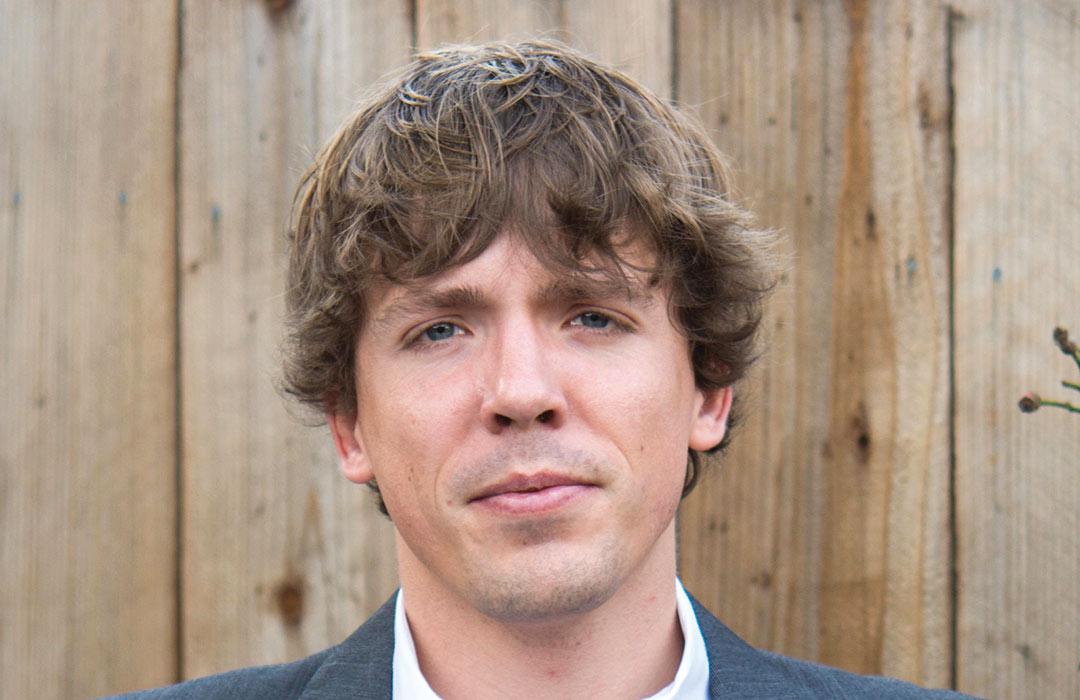 Scott Clark standing in front of fence