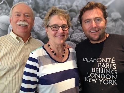 Zelma Long taking group photo with male team members in front of painted backdrop
