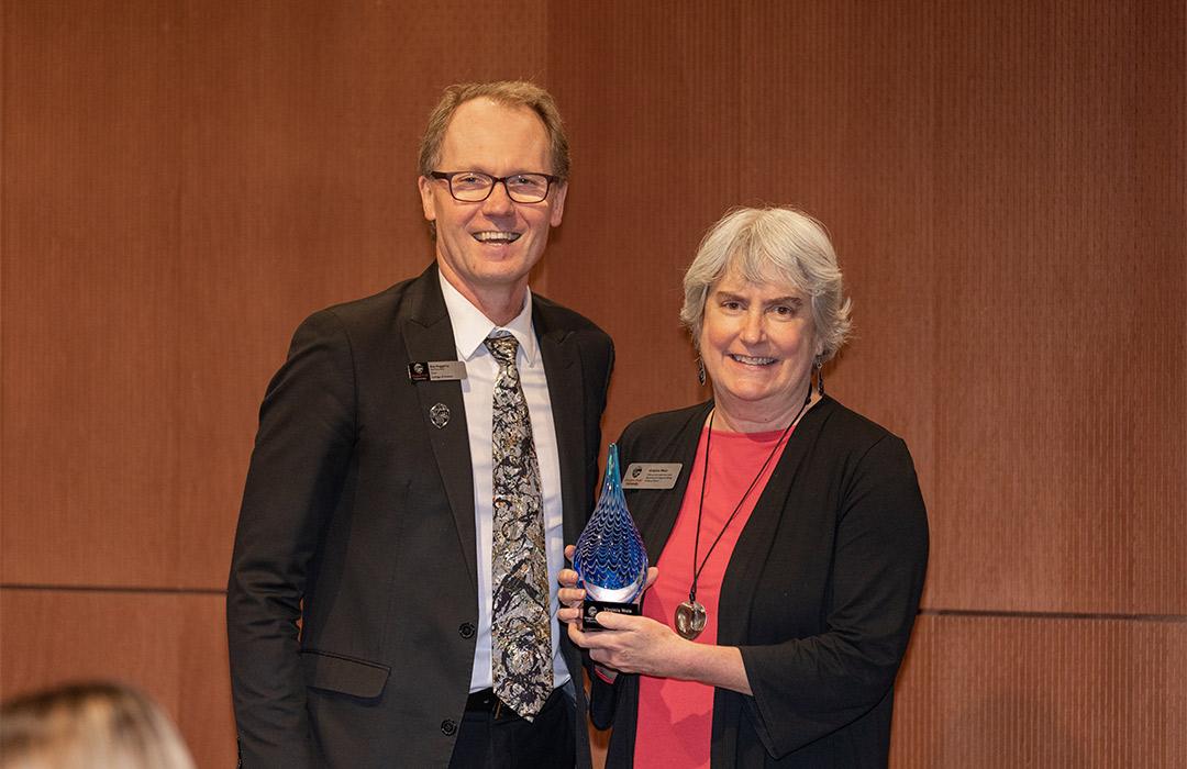 Virginia Wes receiving an award from Dean Haggerty