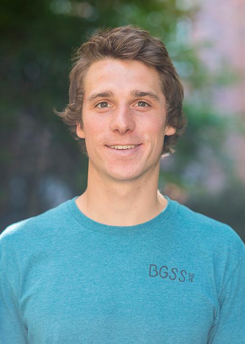 John Stepanek standing in front of shrubbery