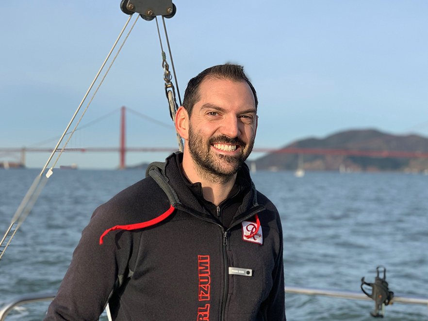 Kenton Hokanson standing on boat in front of the golden gate bridge.