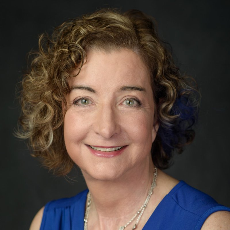 Laura Greene, a woman with short curly hair.