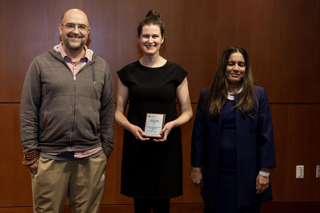 Kirsten Grorud-Colvert stands in a dark dress holding her award.