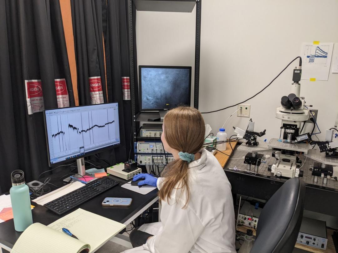 Carley Beeman sits at a desk looking at data on a computer.