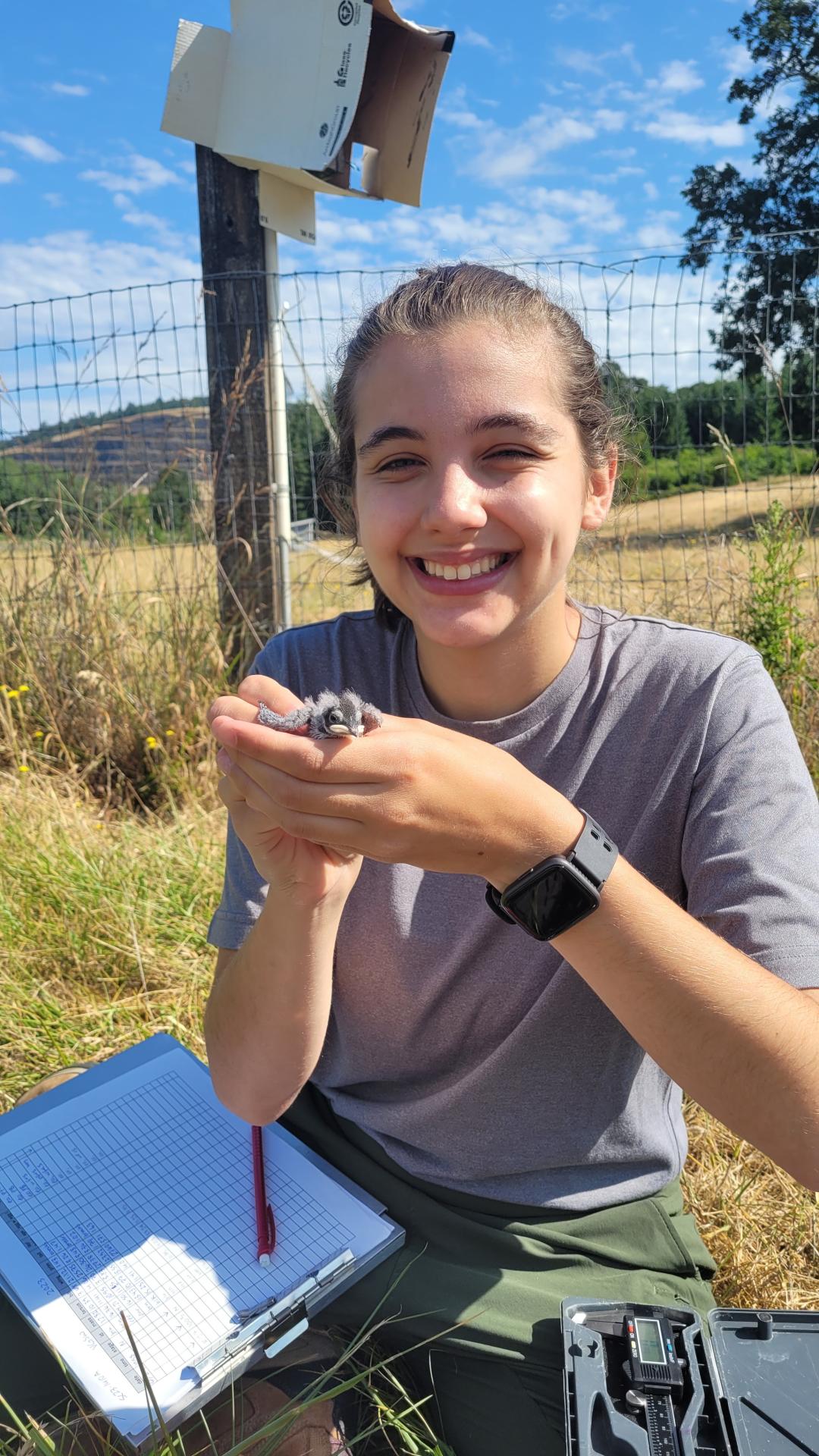 A woman holds a nestling.