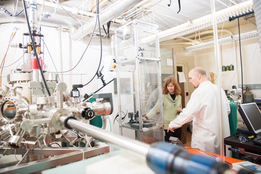 A woman works in a laboratory with a graduate student.