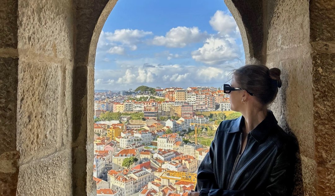 A woman poses for a picture in front of a city in Spain.