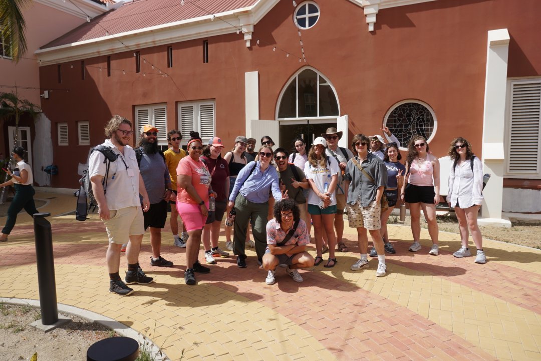 A group of people pose for a photo in front of a building.