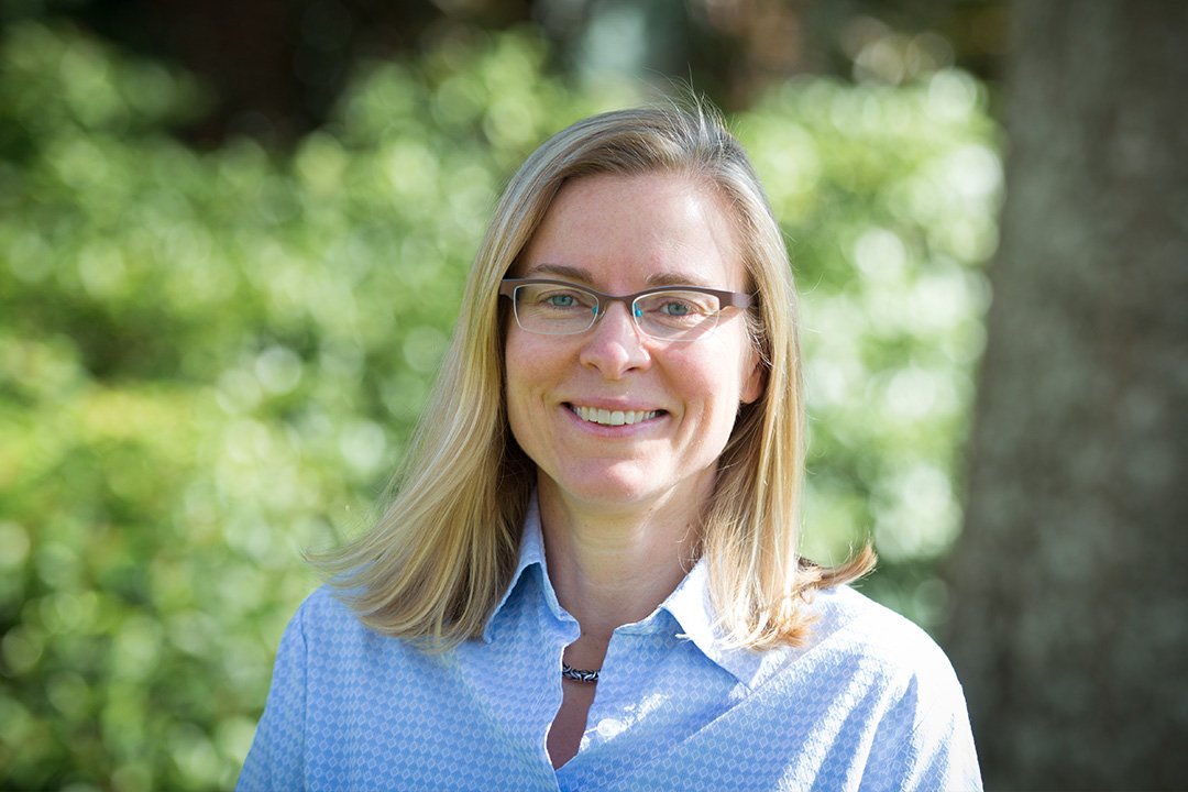 Headshot of a blonde woman in a blue blouse.
