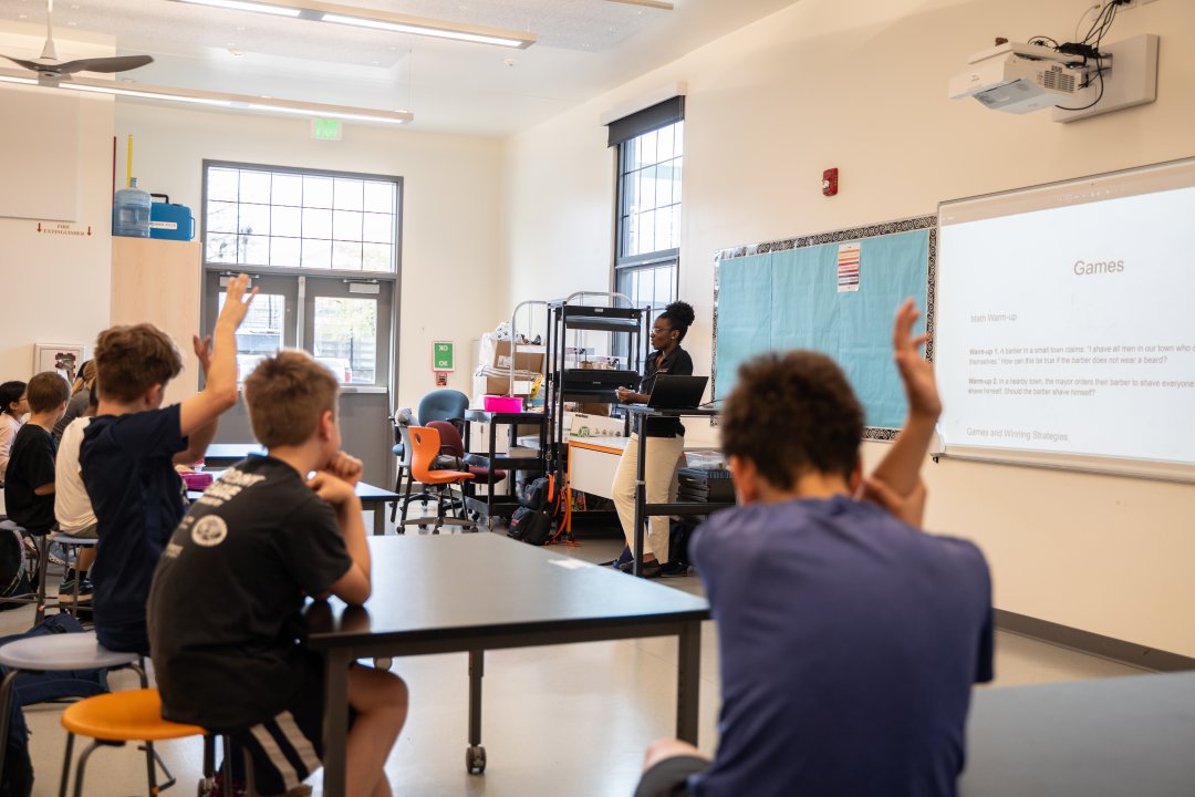 A woman teaches math to elementary students.