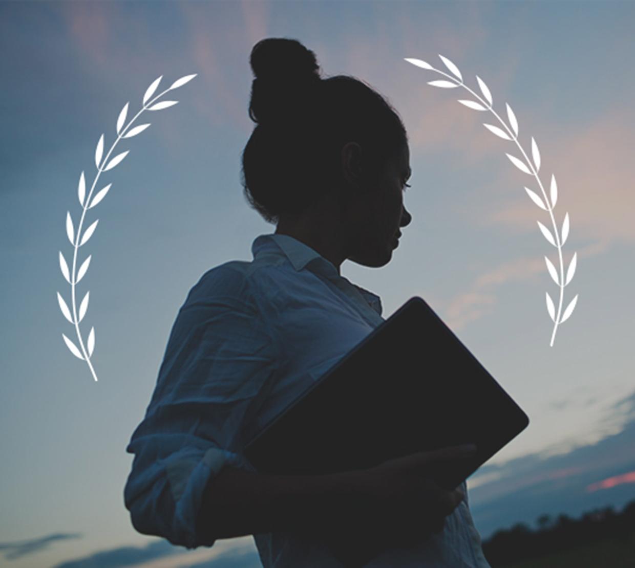 laurel icon above student with book during sunset