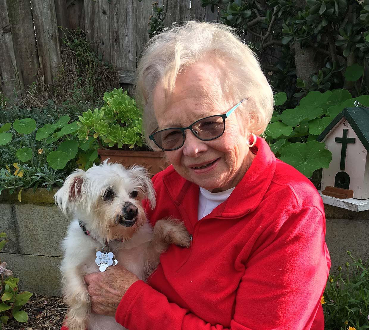 Karen Nickel holding dog in backyard bench