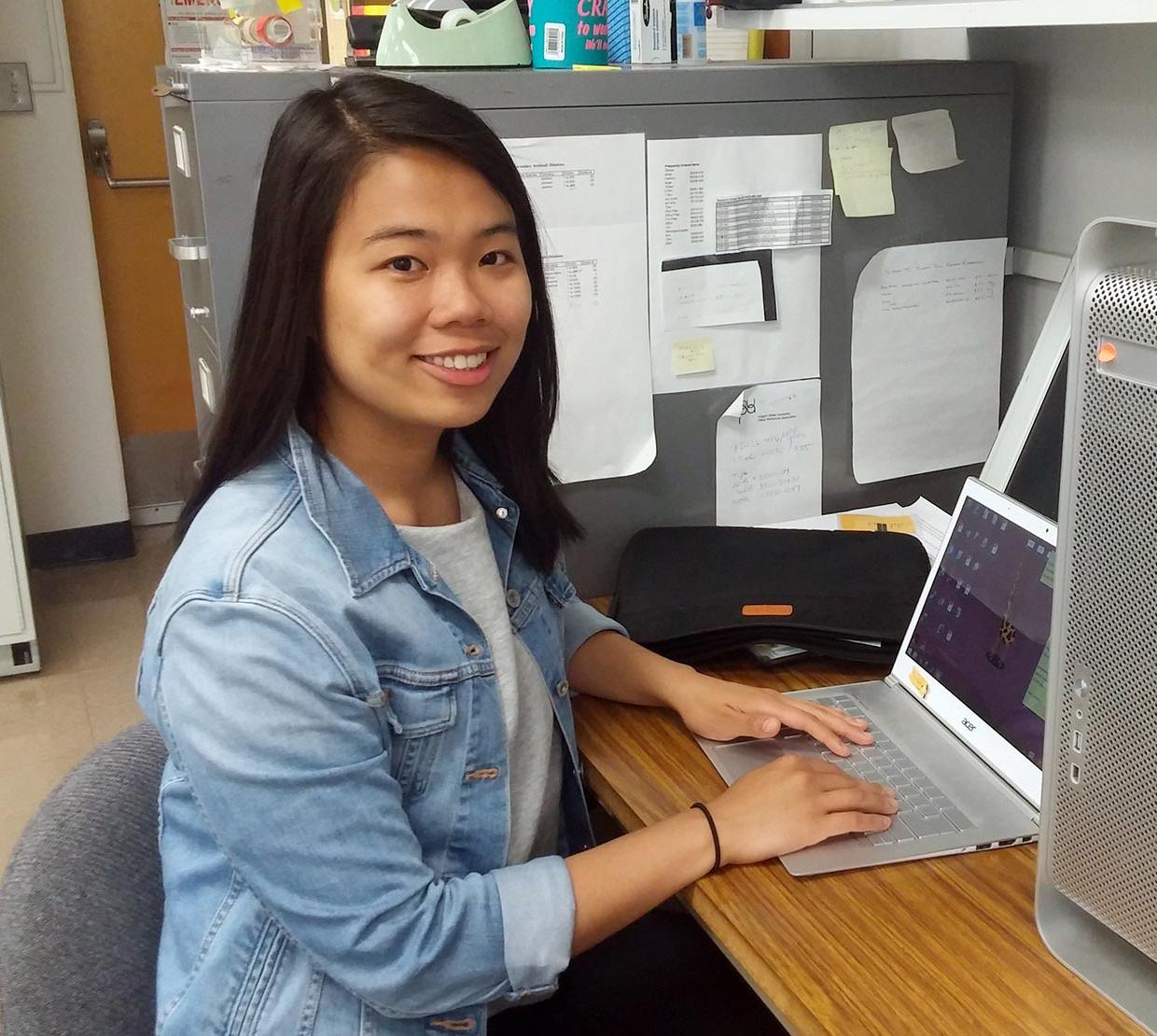 Mai Le working on her laptop in lab