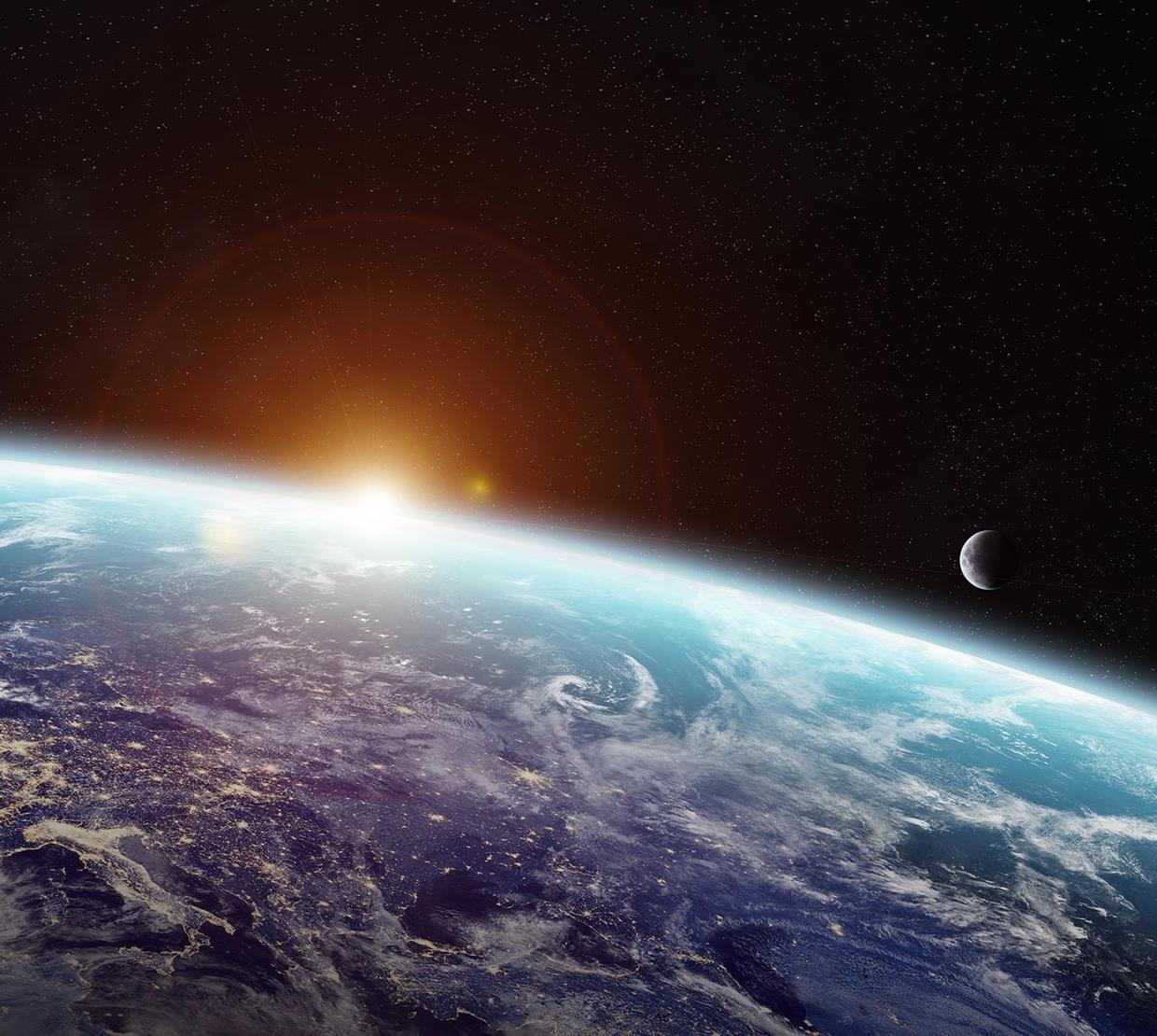 sun peering over earth from space