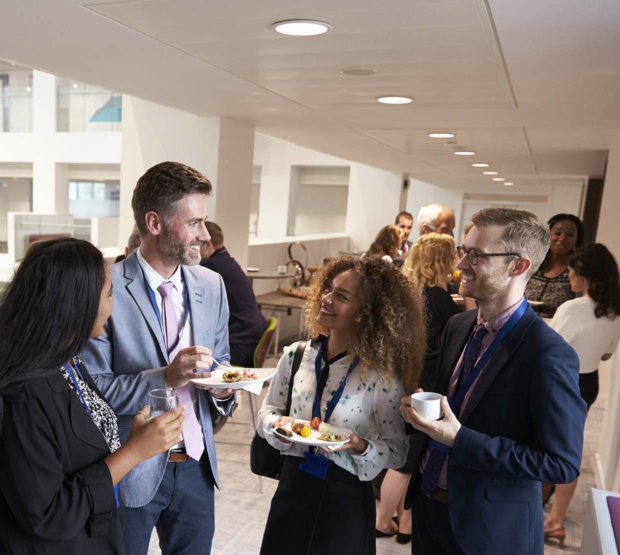 group of people talking to each other at a social event