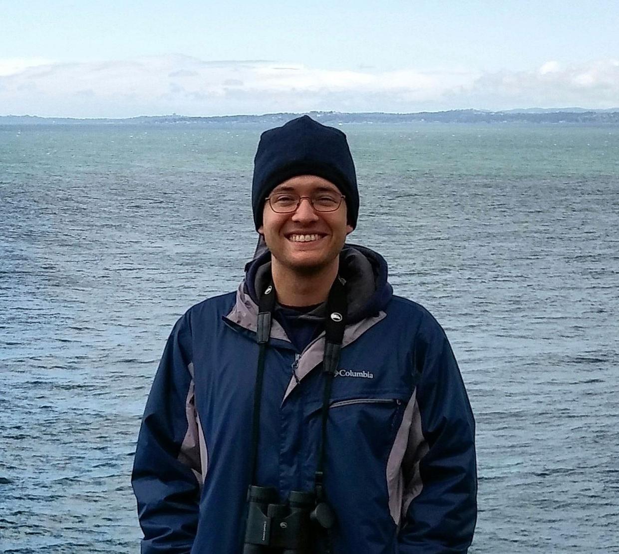 Zech Meunier standing in front of ocean