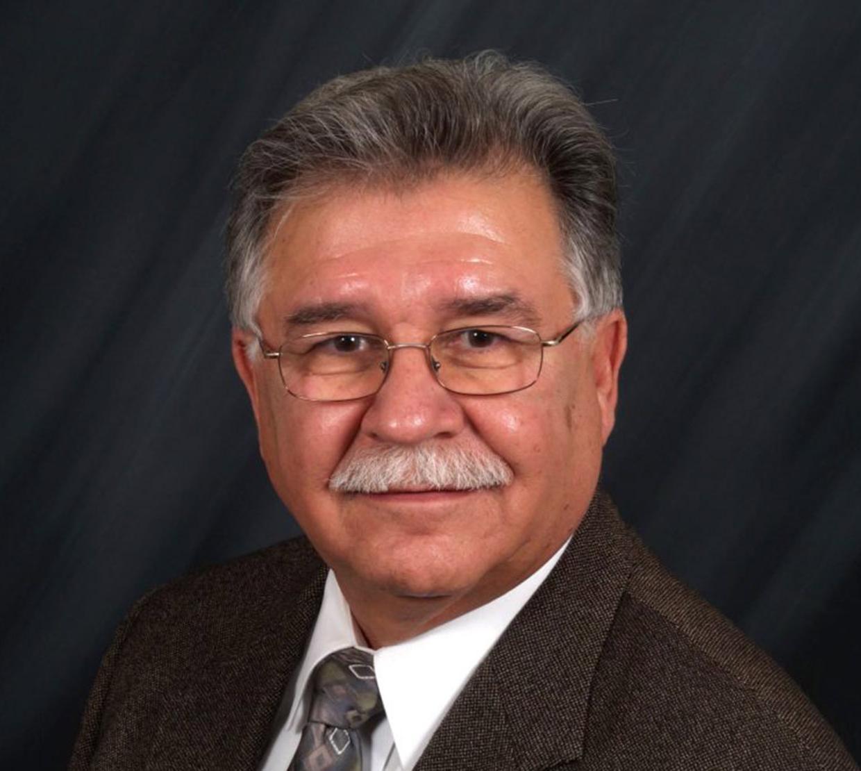 William Yslas Velez in front of grey backdrop