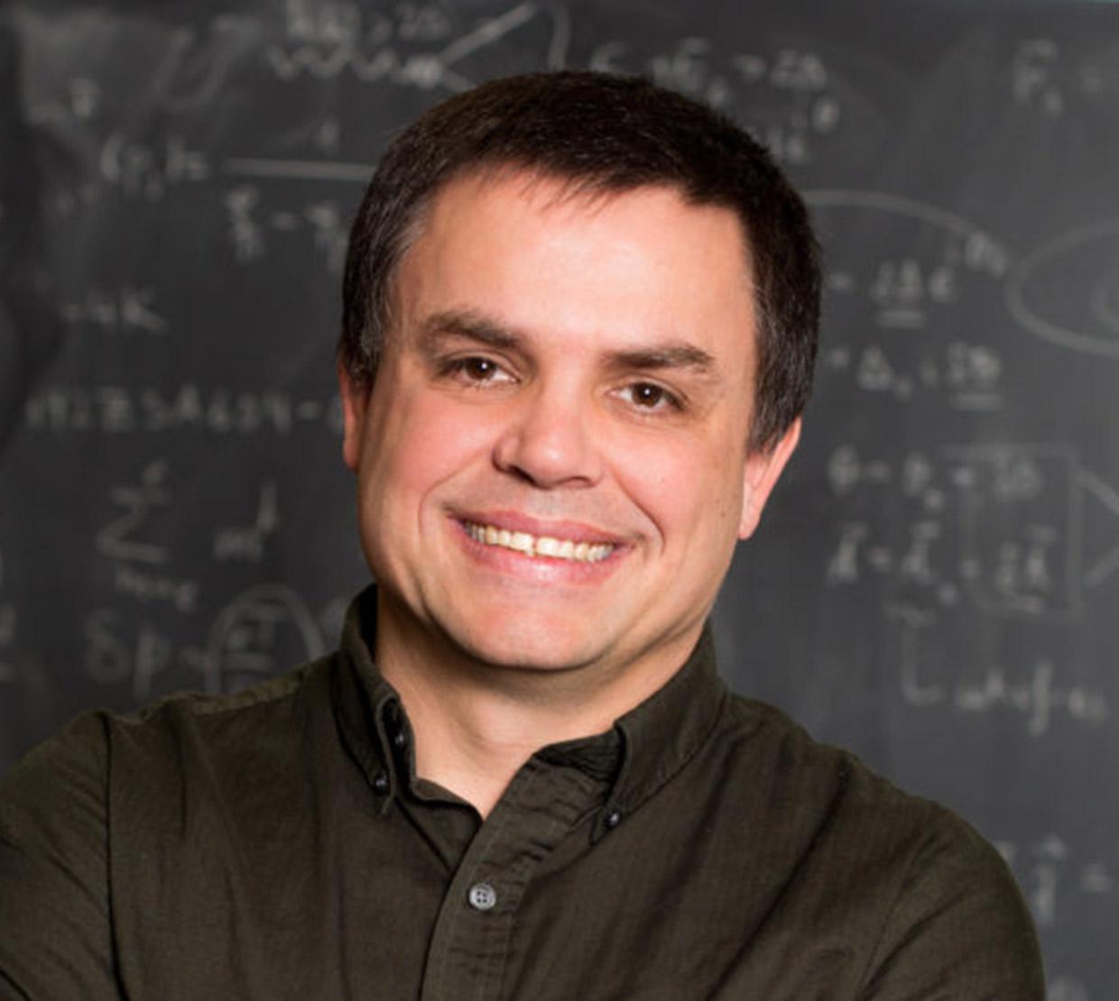 Shane Larson standing in front of chalkboard