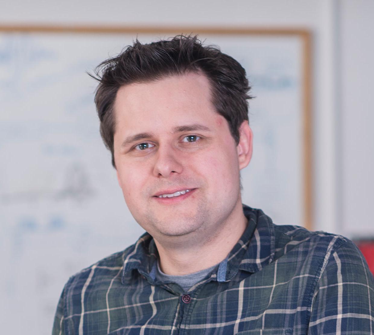 Matt Graham standing in front of white board in lab