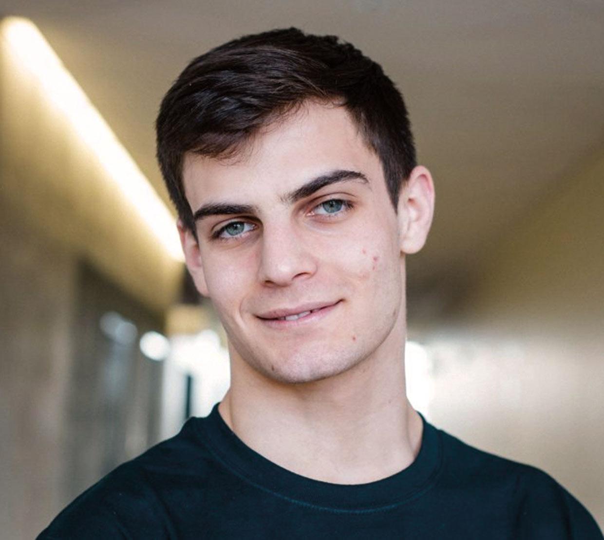 True Gibson standing in lit-up hallway