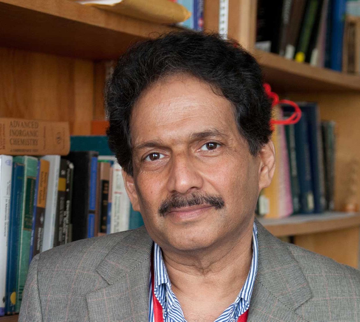 Mas Subramanian standing in front of bookshelf