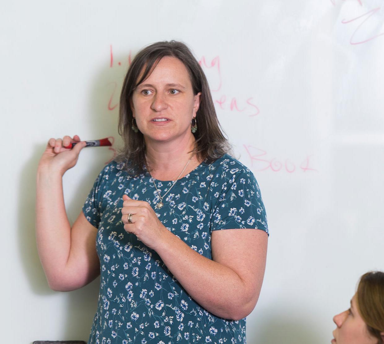 Lori Kayes talking to class from white board