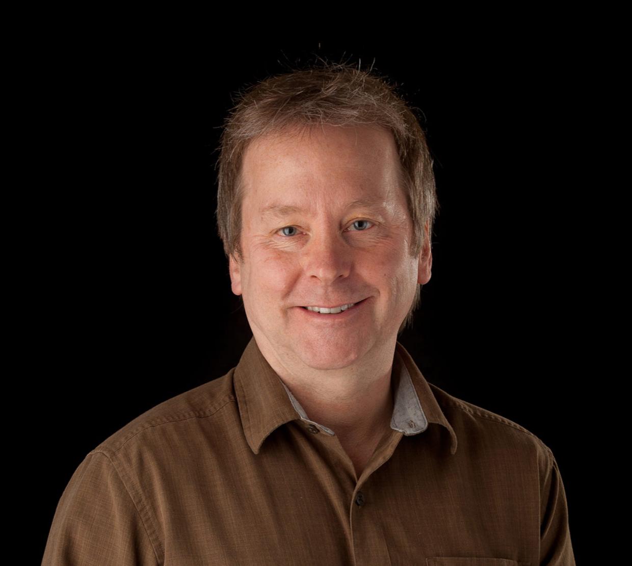 Doug Keszler standing in front of black backdrop