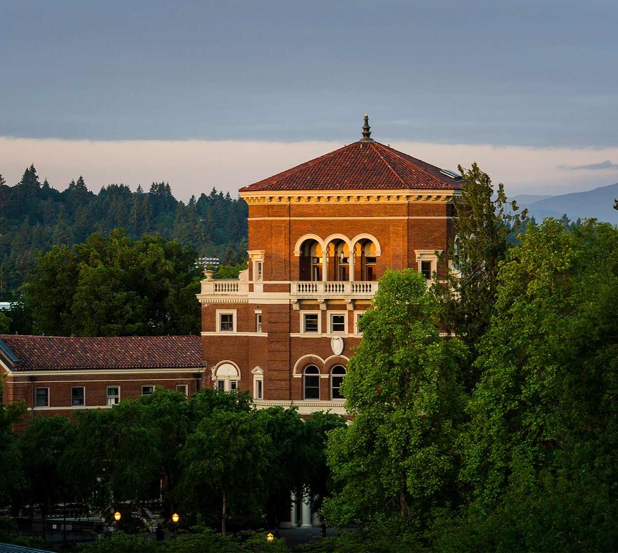 Weatherford Hall peering above trees during sunset.