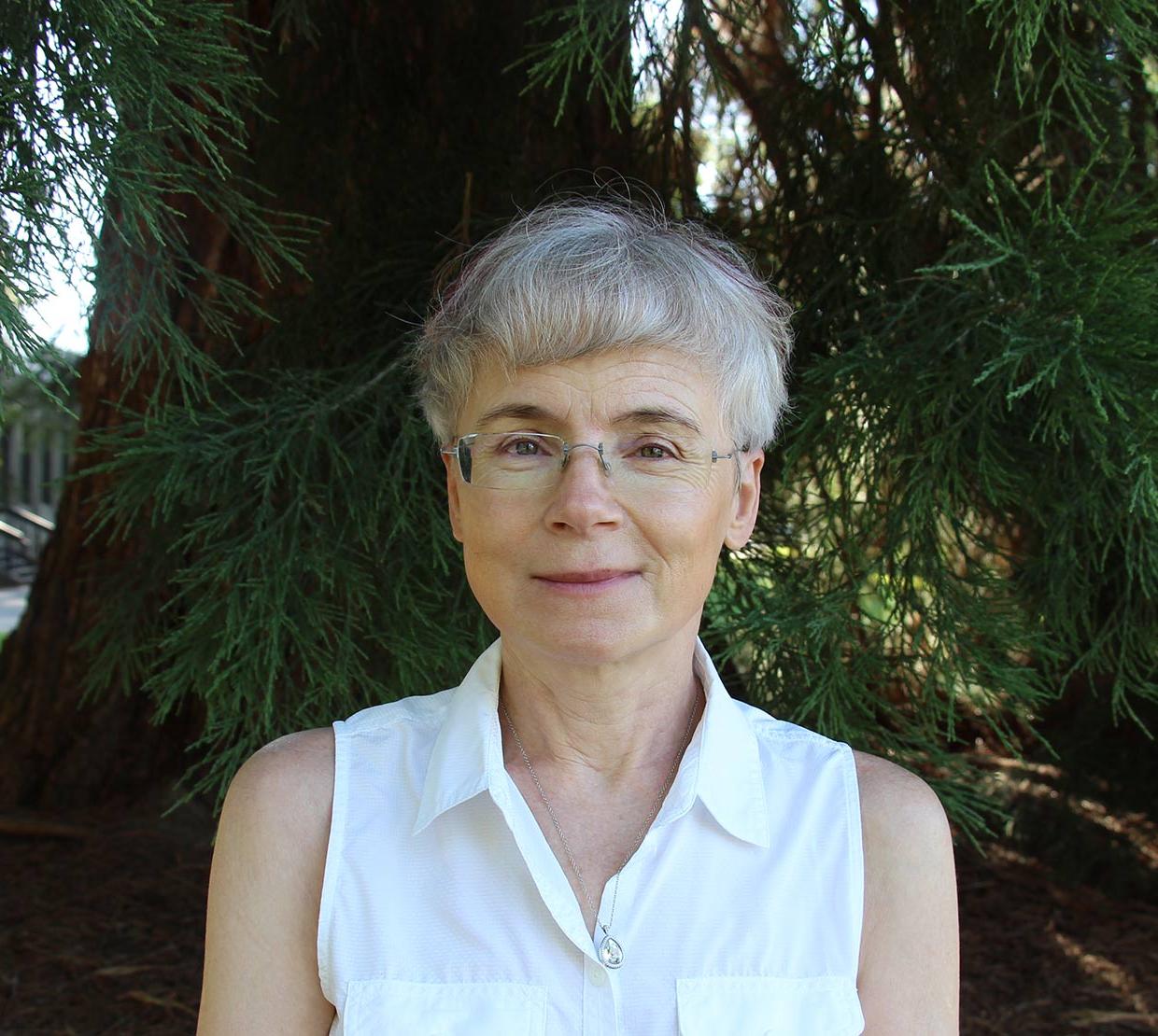 Malgorzata Peszysnka standing in front of a tree.