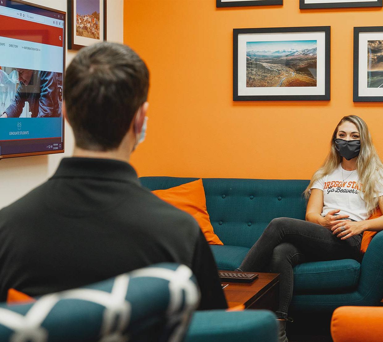 A student and mentor engage wearing masks in the physical-distancing environment.