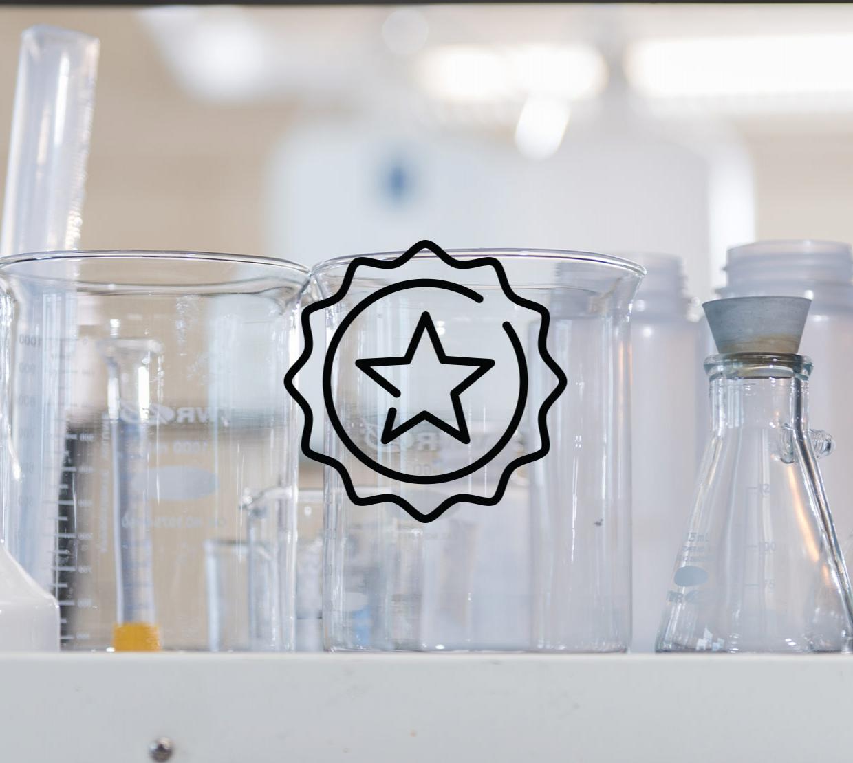 A star badge icon above an image of beakers and lab equipment sitting on a lab table.