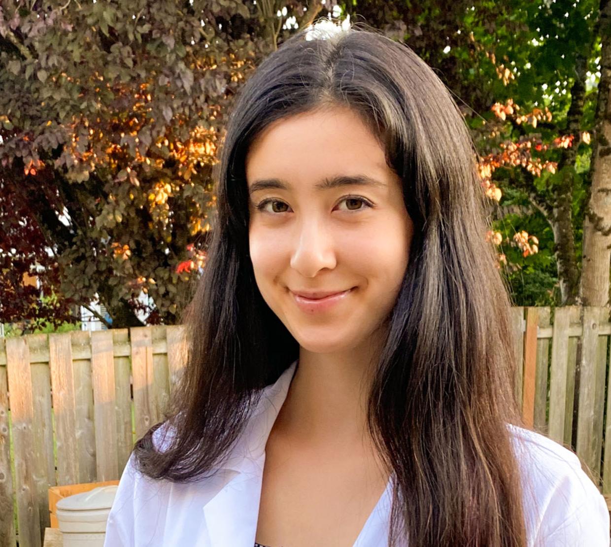 Gretchen Fujimura standing outside in a white lab coat.