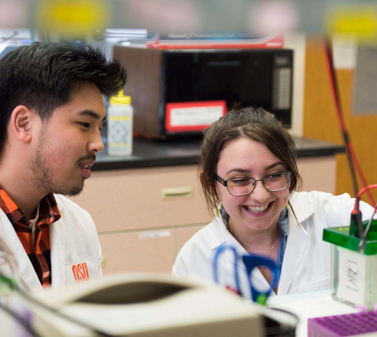 Two students in a lab smiling