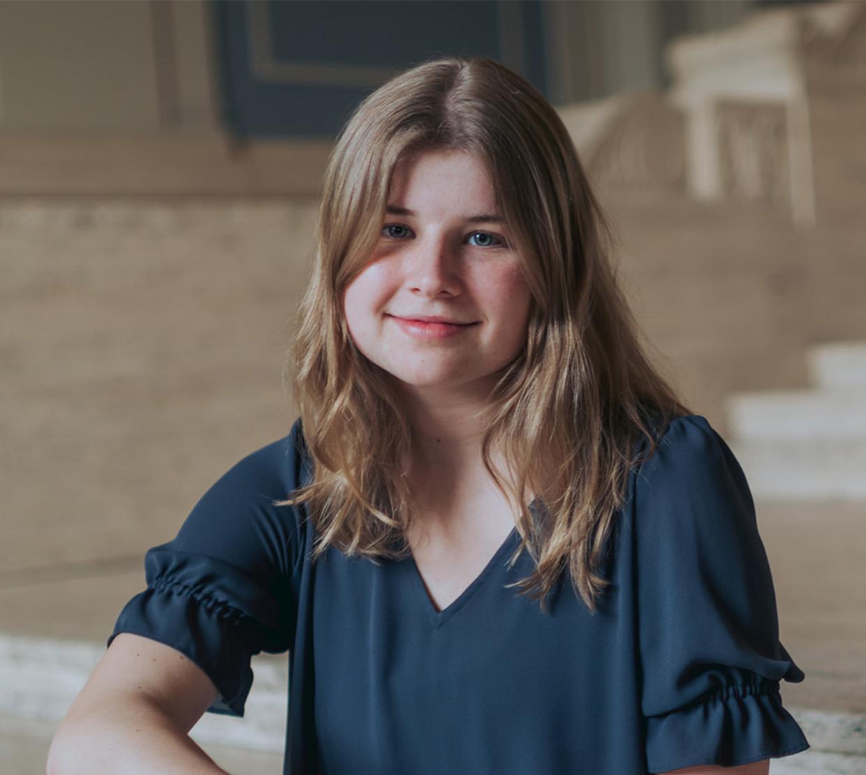 Grace Petrina, a woman with long blonde hair, in a dark blue shirt.