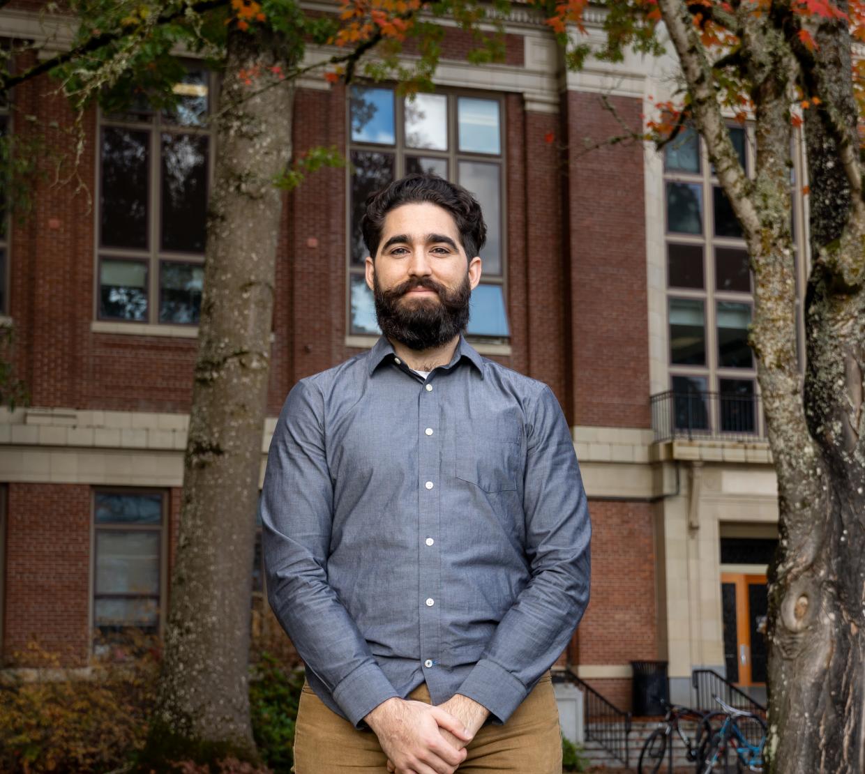 Fernando Angulo Barba stands in a blue shirt and khaki pants in front of Kidder Hall.