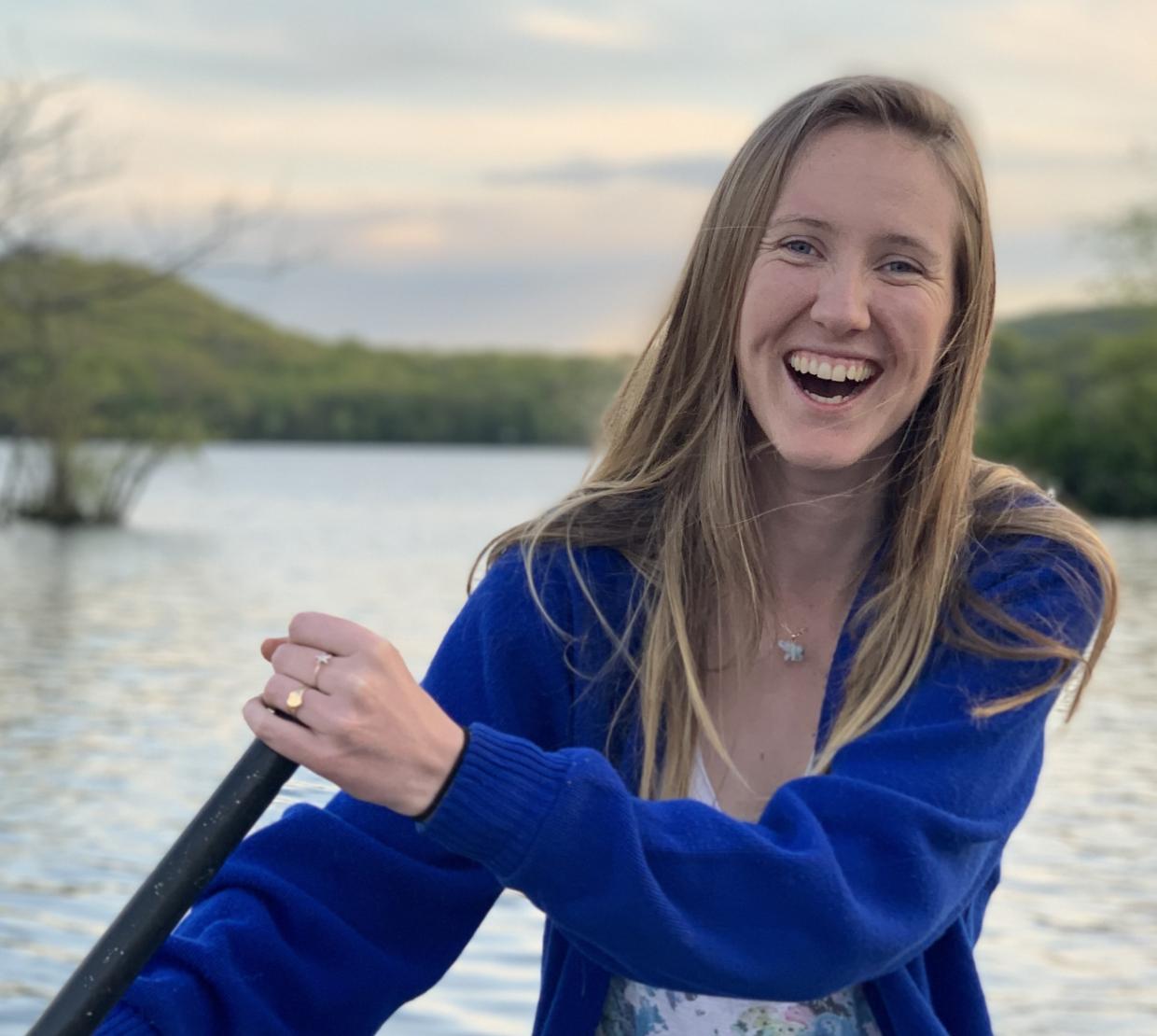 Karianna Crowder laughing while rowing a boat on the water.