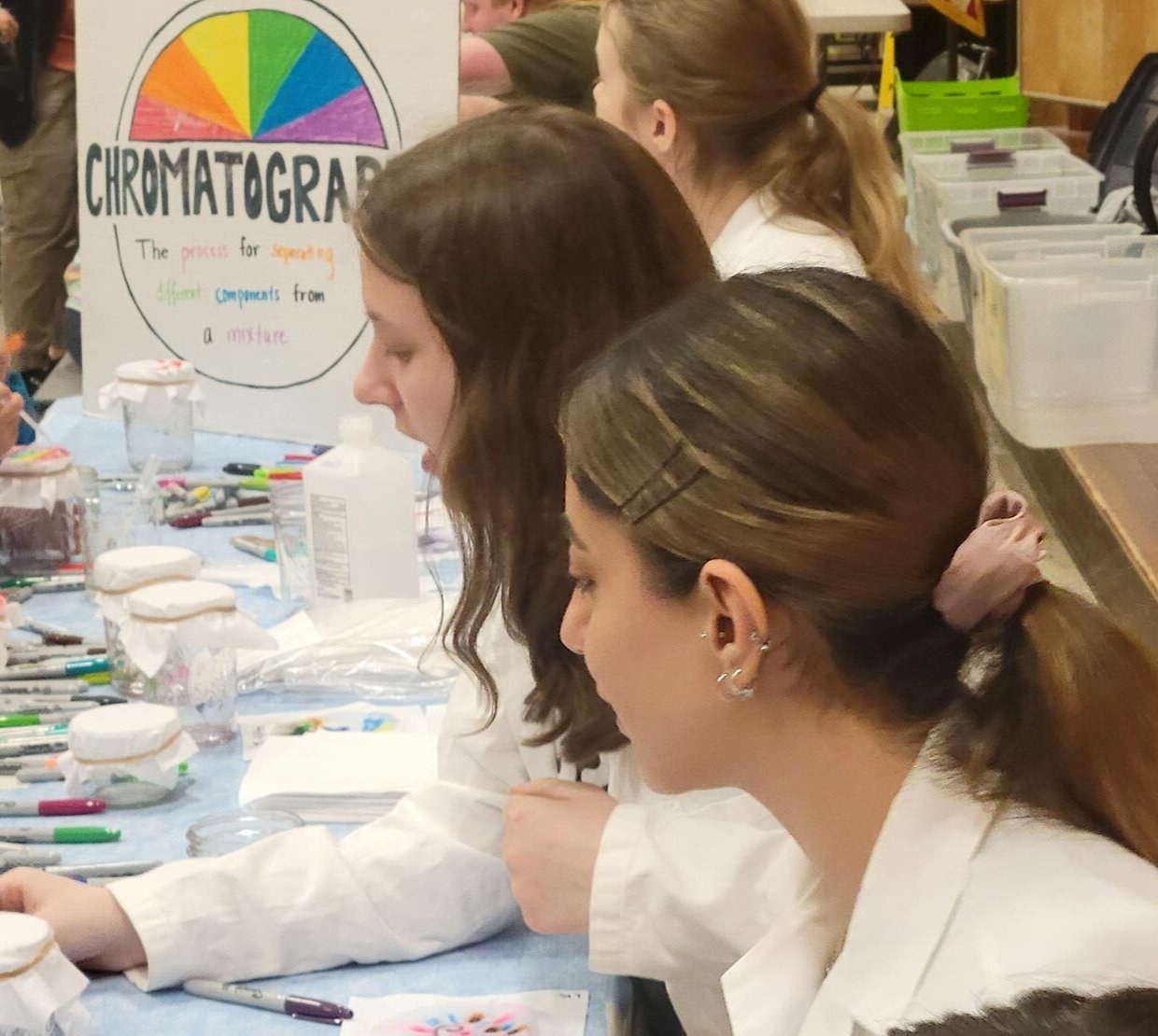 Students at a table work with kids.