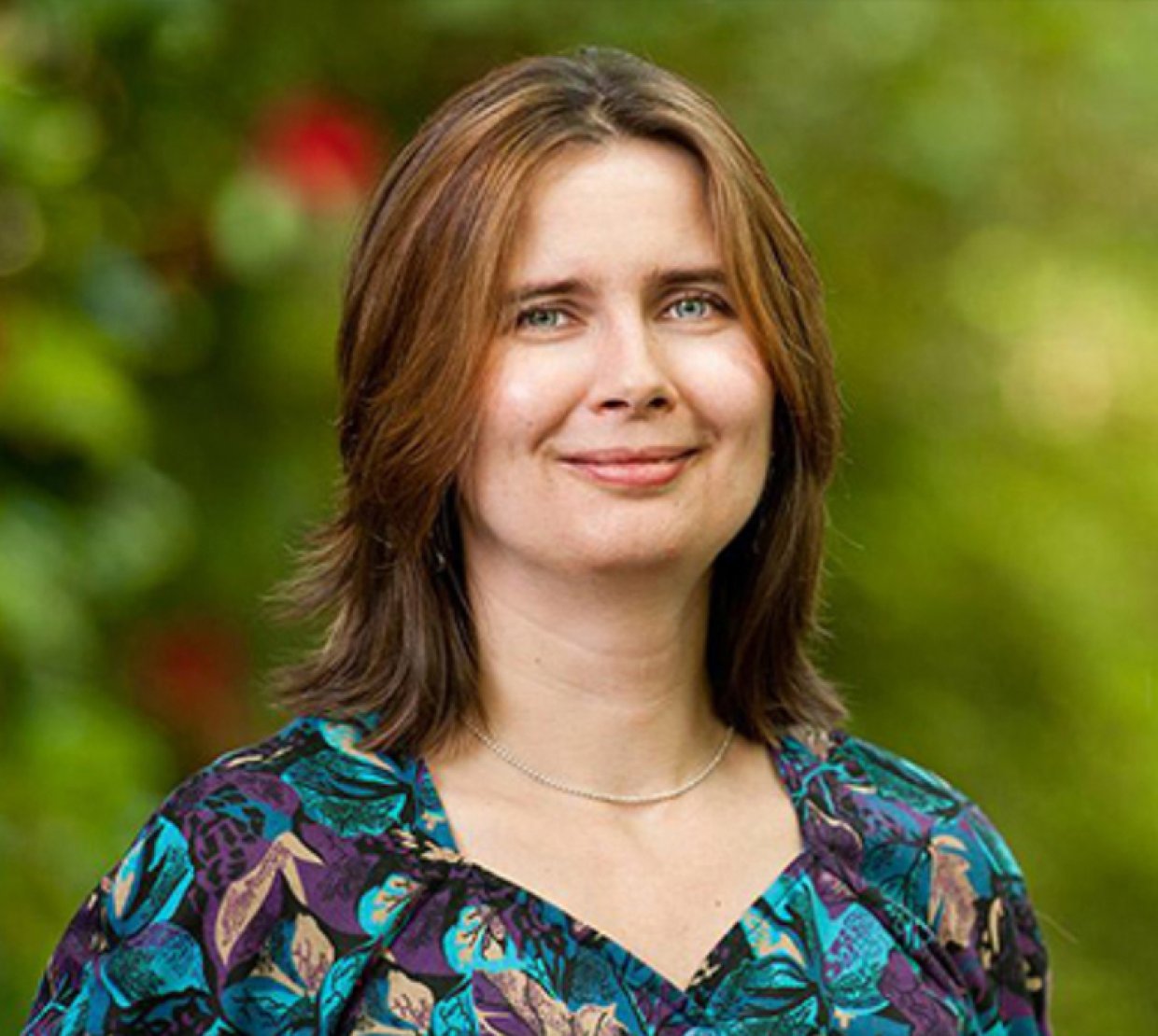 Oksana Ostroverkhova smiling on campus in spring