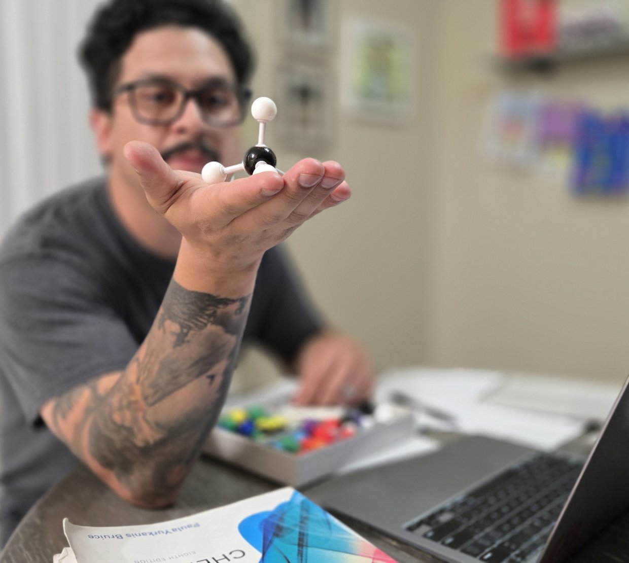 Esteban Contreras holding an atom model from a chemistry kit.