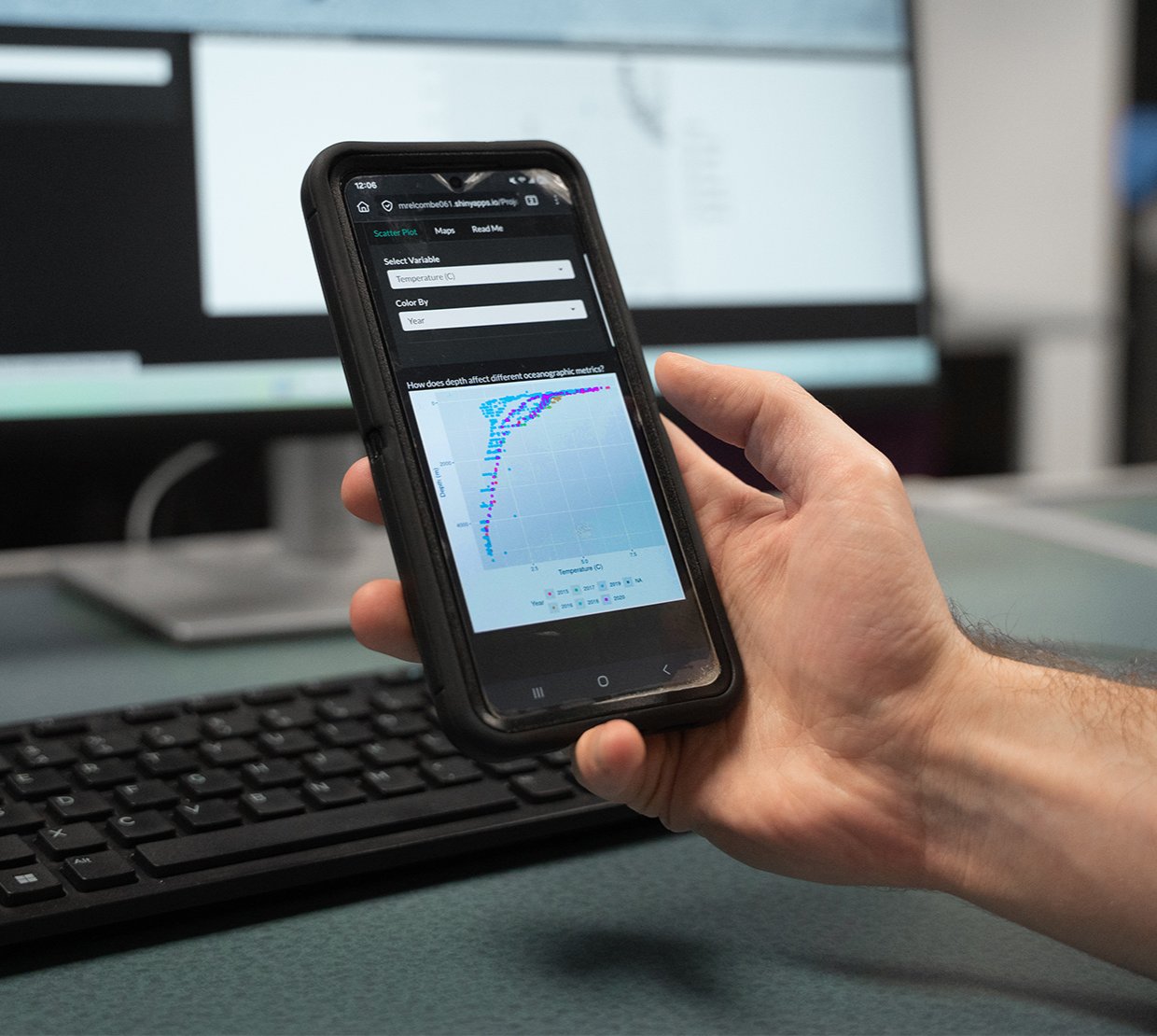 A hand holds a phone with an app open showing data points on a grid.