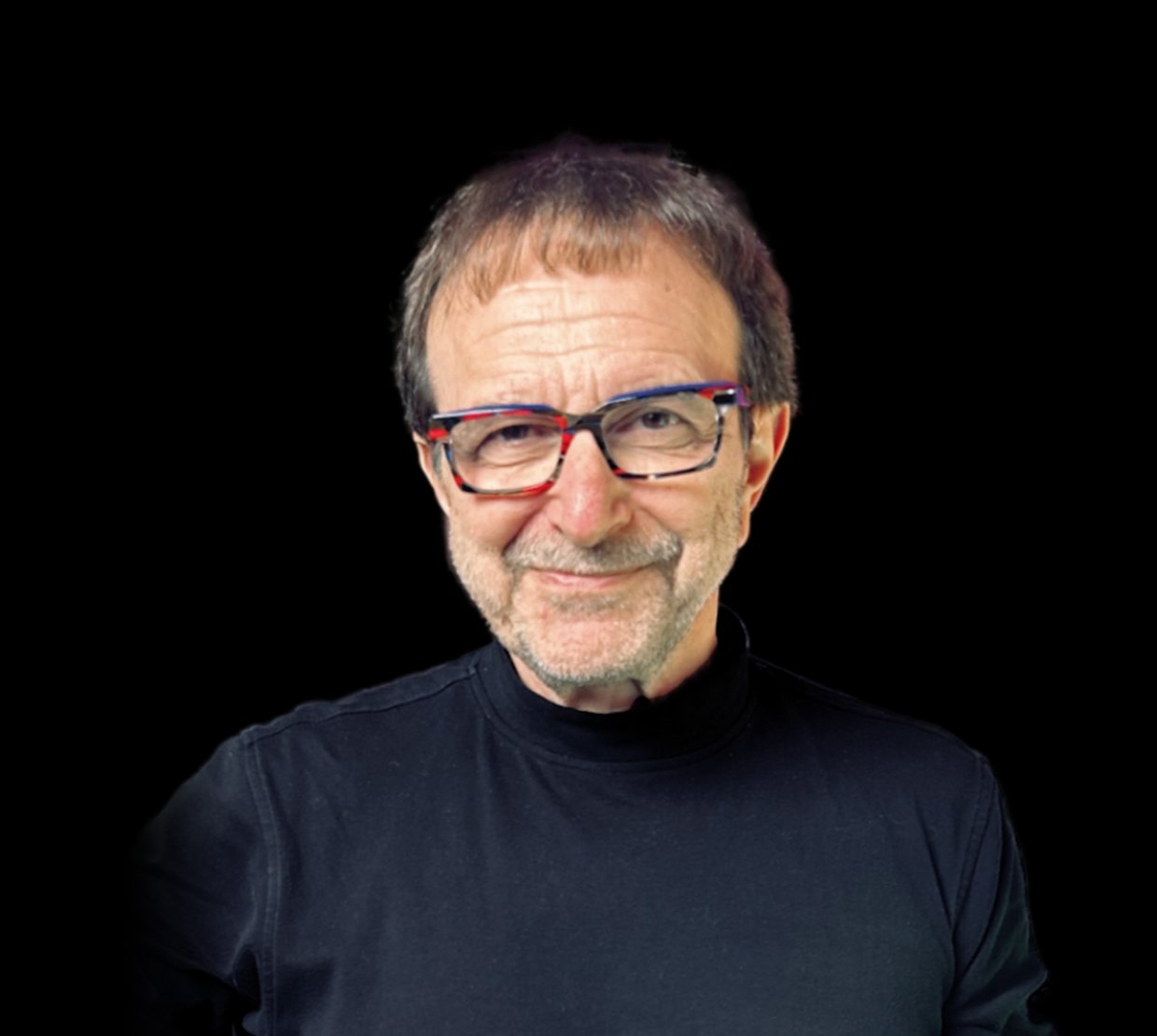 Vincent Racaniello wears a black shirt on a black background and has a playful smile.