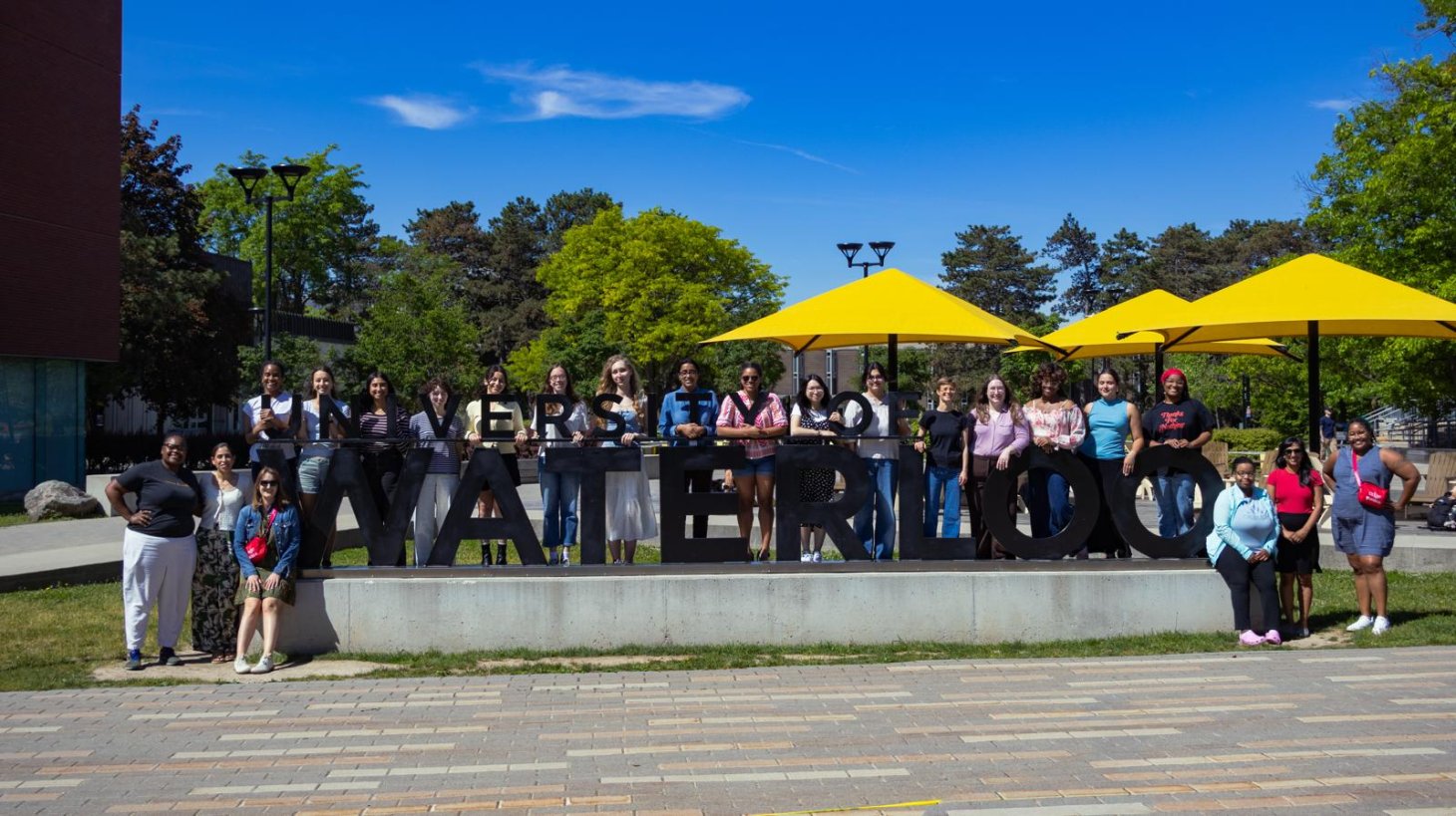 A group of people pose for a photo outside.