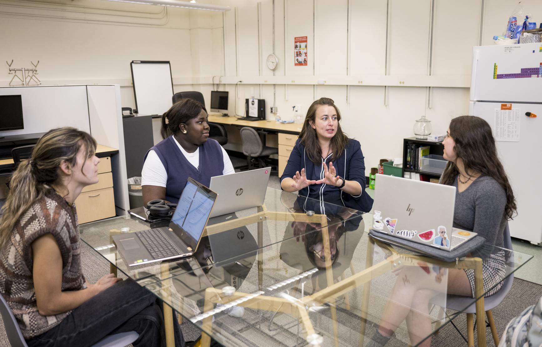 Maude David working with three students in her lab.