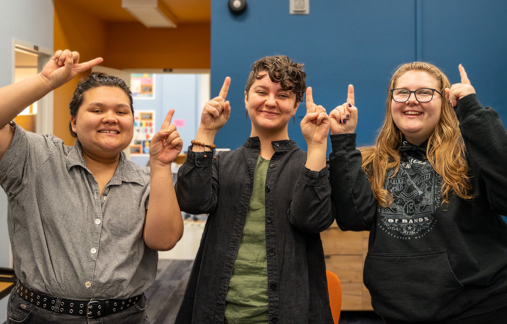 Two peers and Kris smile and point at Kidder 109, where the success center is located