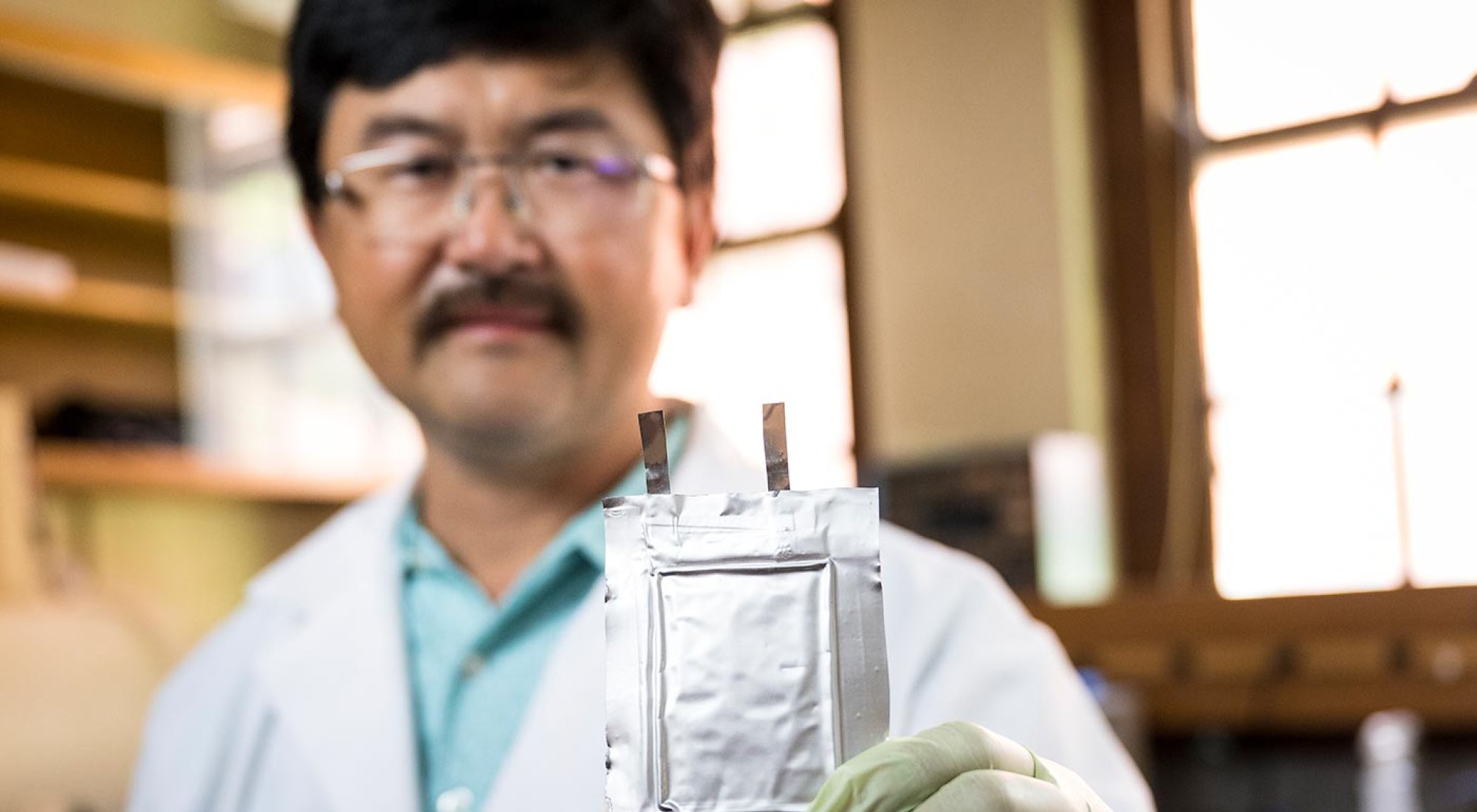David Ji holds a test battery focused in the foreground