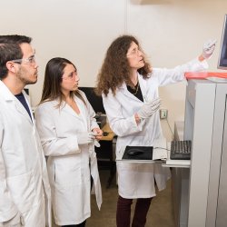 May Nyman and students checking out equipment in lab