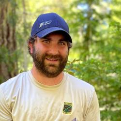 A man with a beard in the forest.