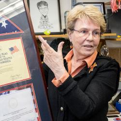 Jane Lubchenco stands in a suit referencing her framed United States flag
