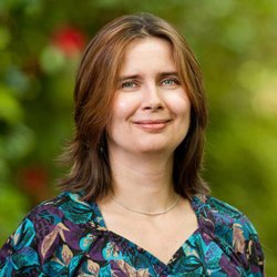 Oksana Ostroverkhova smiling on campus in spring