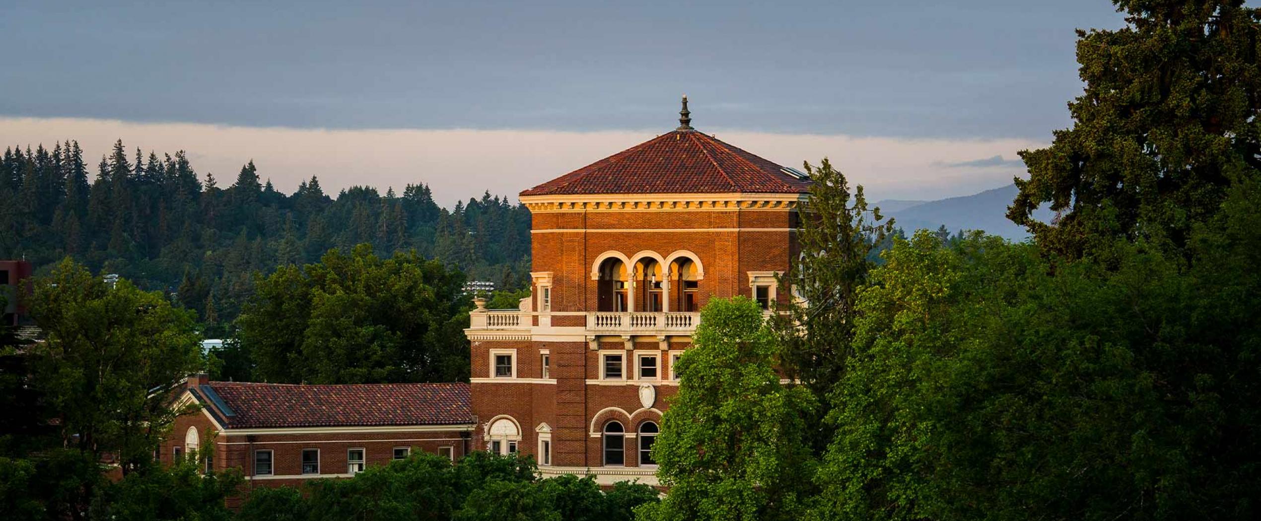 Weatherford Hall peering through some trees.